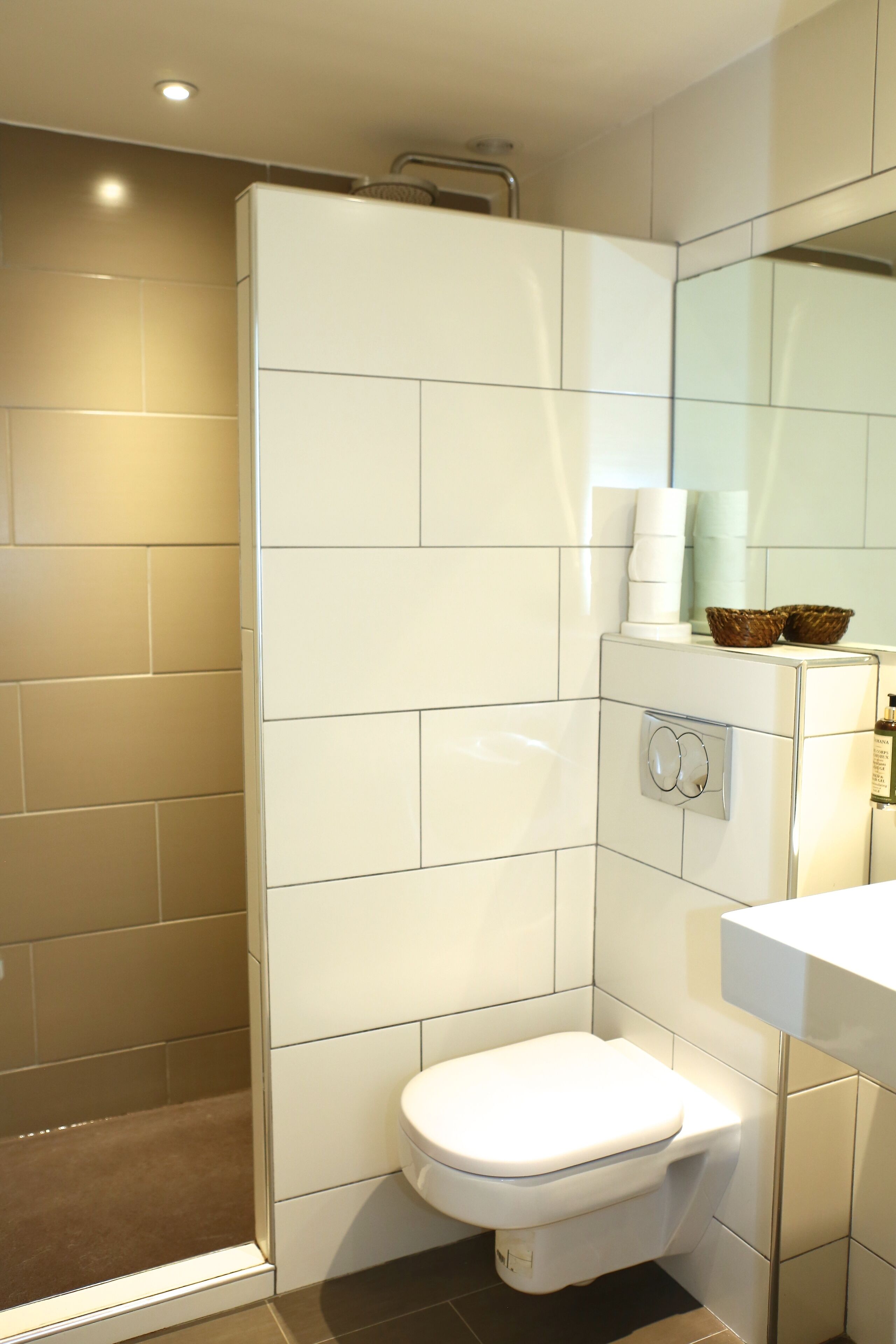 Une salle de bain moderne équipée d’une douche, de toilettes et d’un lavabo.