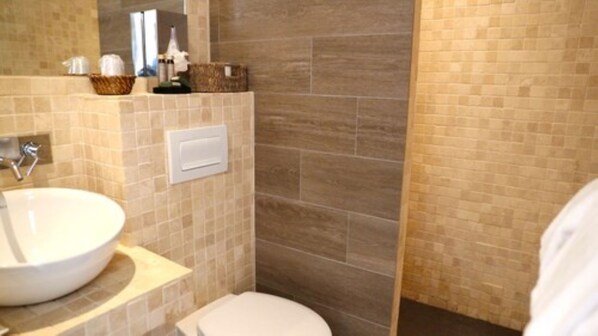 A bathroom with a white sink, a toilet, and a shower area with beige tiles. - Sole e Monti (Quenza)