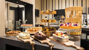 Un buffet proposant une variété de desserts et de pâtisseries présentés sur des planches en bois.