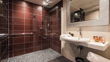 Une salle de bain moderne avec une douche à l’italienne, un meuble-lavabo et un miroir au-dessus du lavabo.
