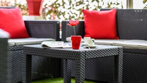 A wicker table with a red vase and a newspaper. - Auberge L'Estanquet (Urt)