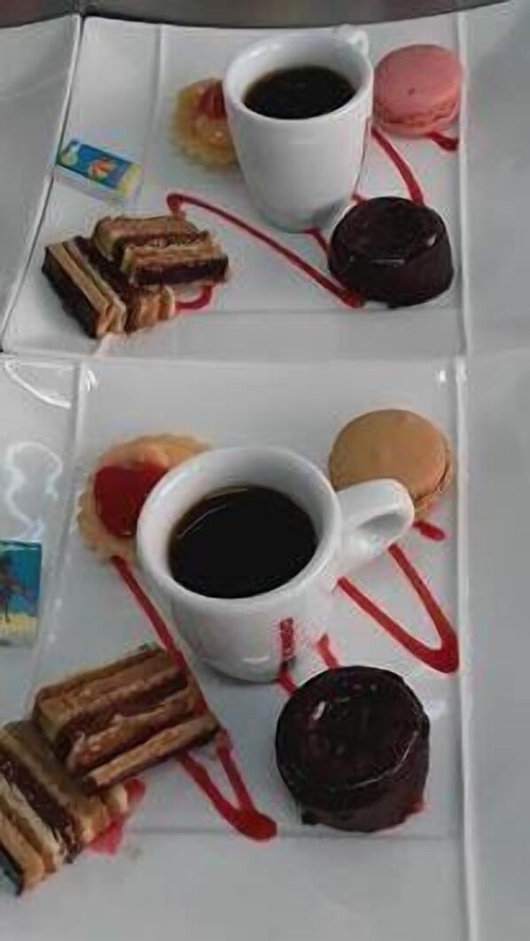 A tray with a cup of coffee, macarons, and assorted pastries. - Hôtel Restaurant Le Cheval Blanc (Cerizay)