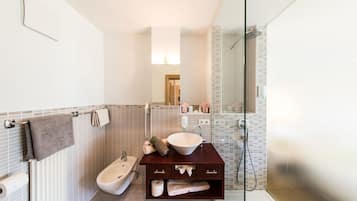 Een moderne badkamer met een vrijstaand bad, een wastafelmeubel met een ruime wasbak en een douchecel met glazen wanden.