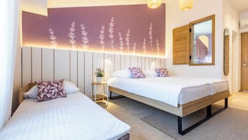 A modern bedroom with two beds, a wall-mounted mirror, and a decorative light fixture.