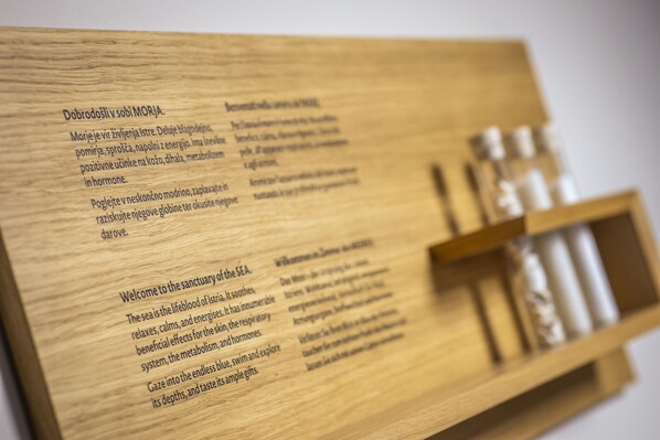 A wooden board with text and a shelf holding small bottles. - Hotel Histrion - Sava Hotels & Resorts (Piran)