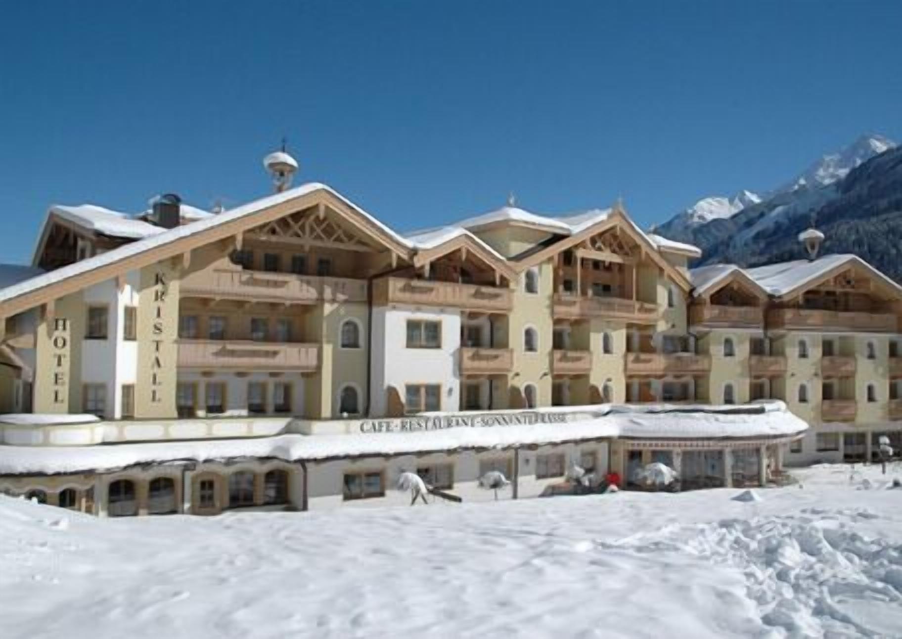 A hotel with multiple balconies and a snow-covered ground.
