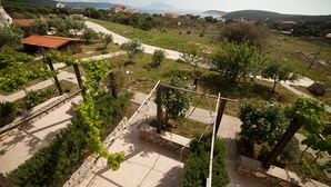 Paisaje rural con viñedos, senderos de piedra y edificios tradicionales.