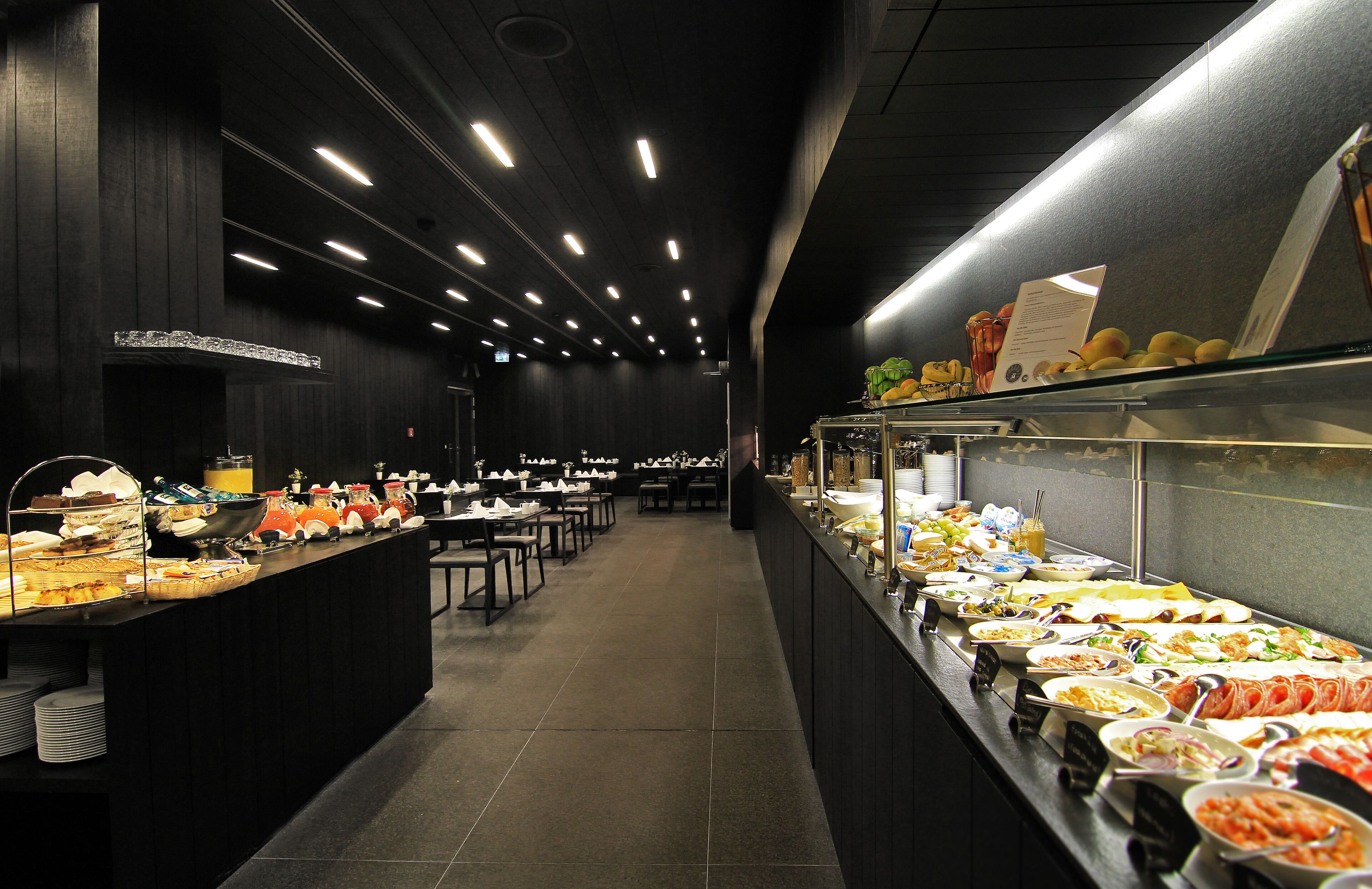 Un espace buffet comprenant plusieurs stands de restauration et des tables.