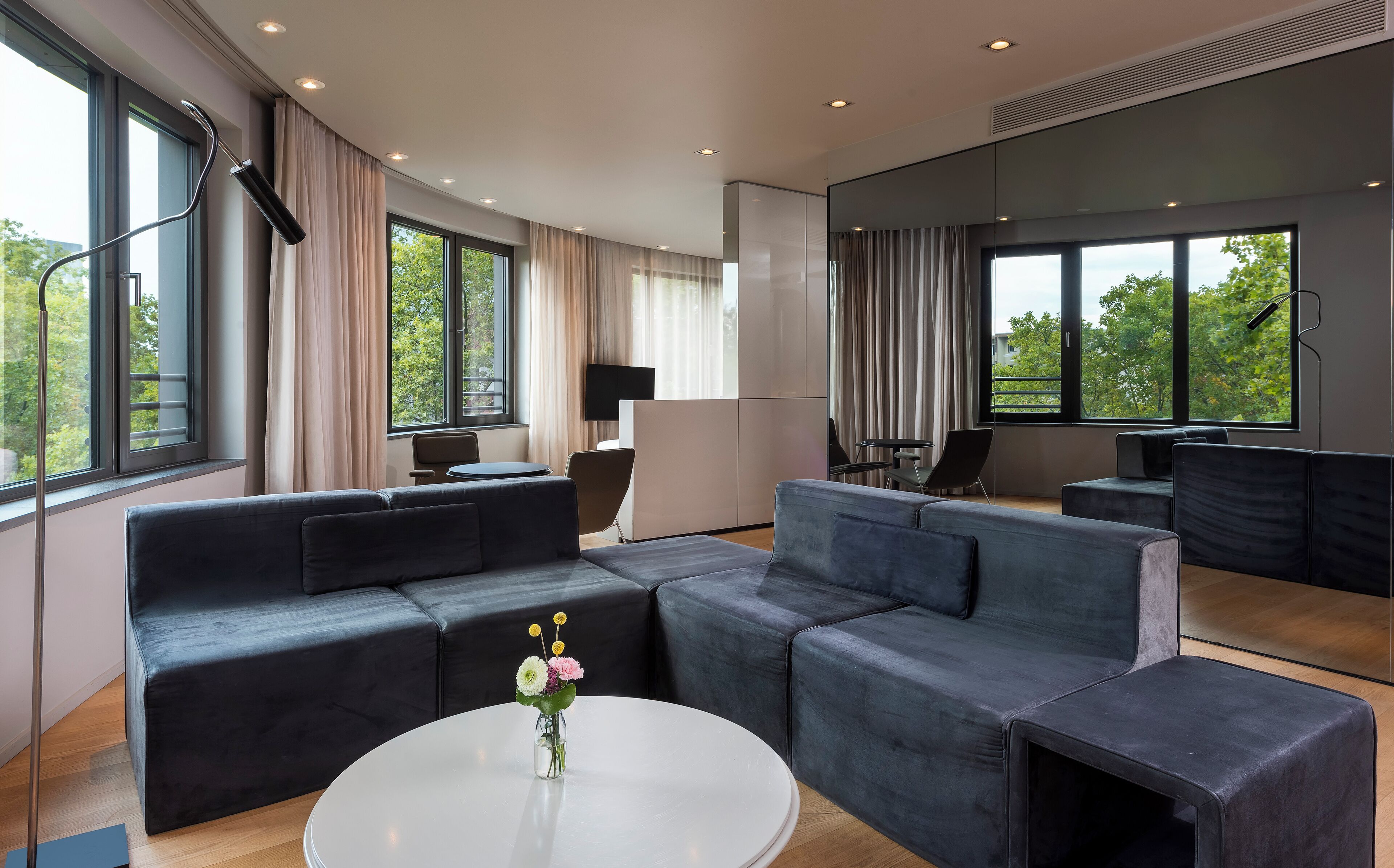 A modern living room with a sectional sofa, a round coffee table, and a flat-screen TV.