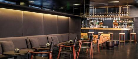 A modern bar area with seating and a bar counter.