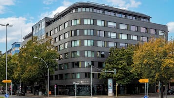 A modern building with a curved facade, large windows, and a sign reading 'SANA BERLIN.'