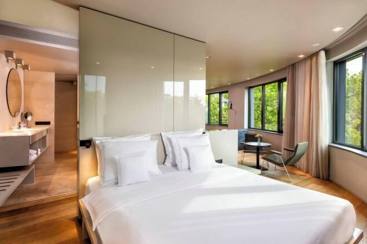 Moderni hotellihuone, jossa on suuri sänky, työpöytä ja tuoli.
