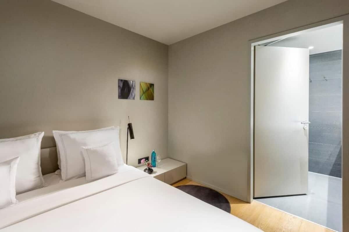 Ropa de cama hipoalergénica y caja de seguridad en la habitación