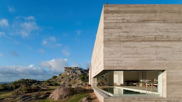 Alberca techada, alberca al aire libre y camastros