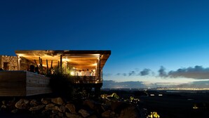 Un edificio moderno con fachada de madera y un balcón con vistas al paisaje.
