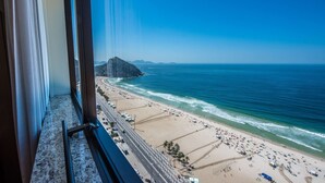 A beach view from a window with a view of the ocean and a distant mountain. - Hilton Copacabana Rio de Janeiro (Rio de Janeiro)