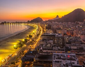 A coastal cityscape with a beach, buildings, and a mountain in the background. - Hilton Copacabana Rio de Janeiro (Rio de Janeiro)