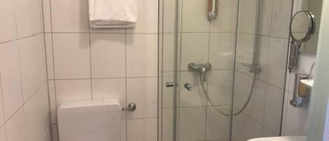 Un baño moderno con ducha de vidrio, inodoro y lavamanos.