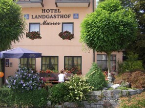 A hotel named "Hotel Landgasthof Murrer" with outdoor seating and flower boxes above the windows. - AKZENT Hotel Landgasthof Murrer (Aiterhofen)