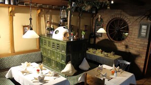 Un restaurant avec des meubles de couleur verte, des tables blanches et une grande roue.