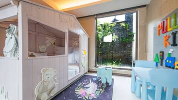 Children can play and explore in this vibrant playroom featuring a playhouse with a bear and horse decoration.