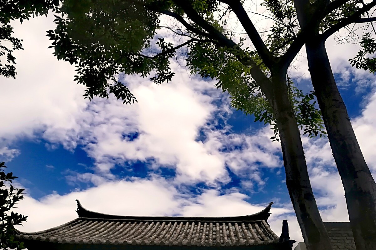 A traditional building with a curved roof and a brick wall.