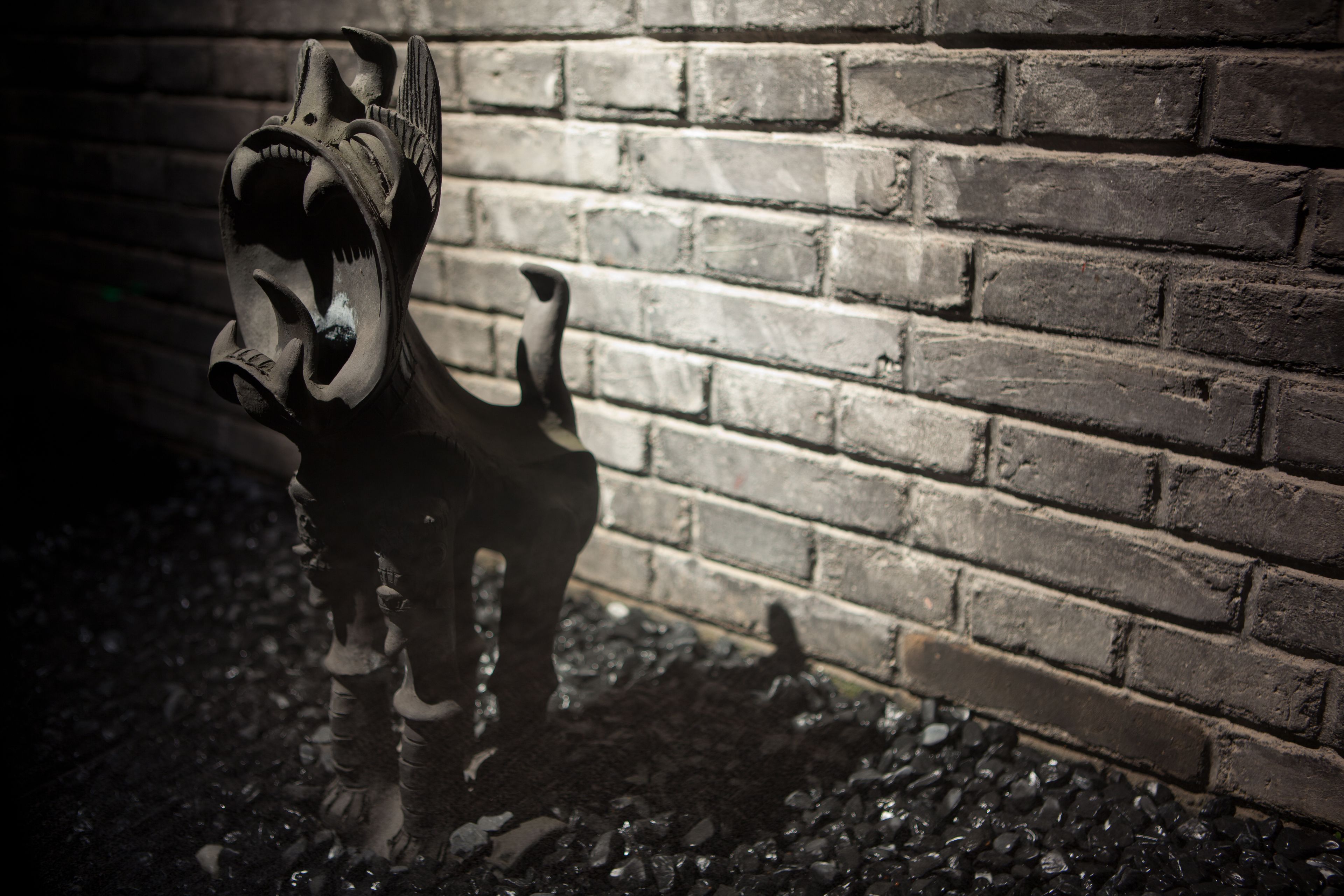 Una escultura de cabeza de caballo montada sobre un muro de ladrillo.