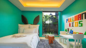 A bedroom with a bed, a desk, and a window.