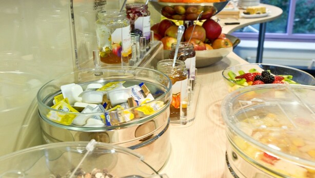 Una mesa de buffet con diferentes alimentos y recipientes.