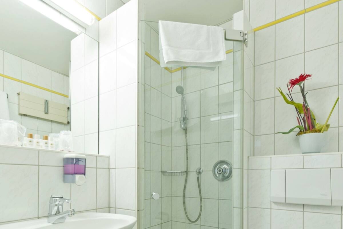 A modern bathroom with a glass-enclosed shower, a sink, and a toilet.