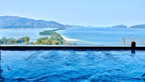 A pool with a view of a coastal landscape, including a beach and distant mountains. - Genmyoan (Miyazu)
