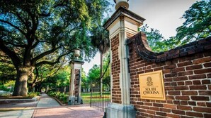 A brick wall with a plaque reading "University of South Carolina" and a pathway leading through a landscaped area with trees. - Hilton Garden Inn Columbia Northeast (Columbia)