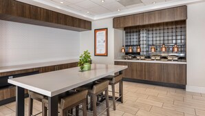 A modern kitchen with a central island, wooden cabinets, and stainless steel appliances. - Hilton Garden Inn Columbia Northeast (Columbia)