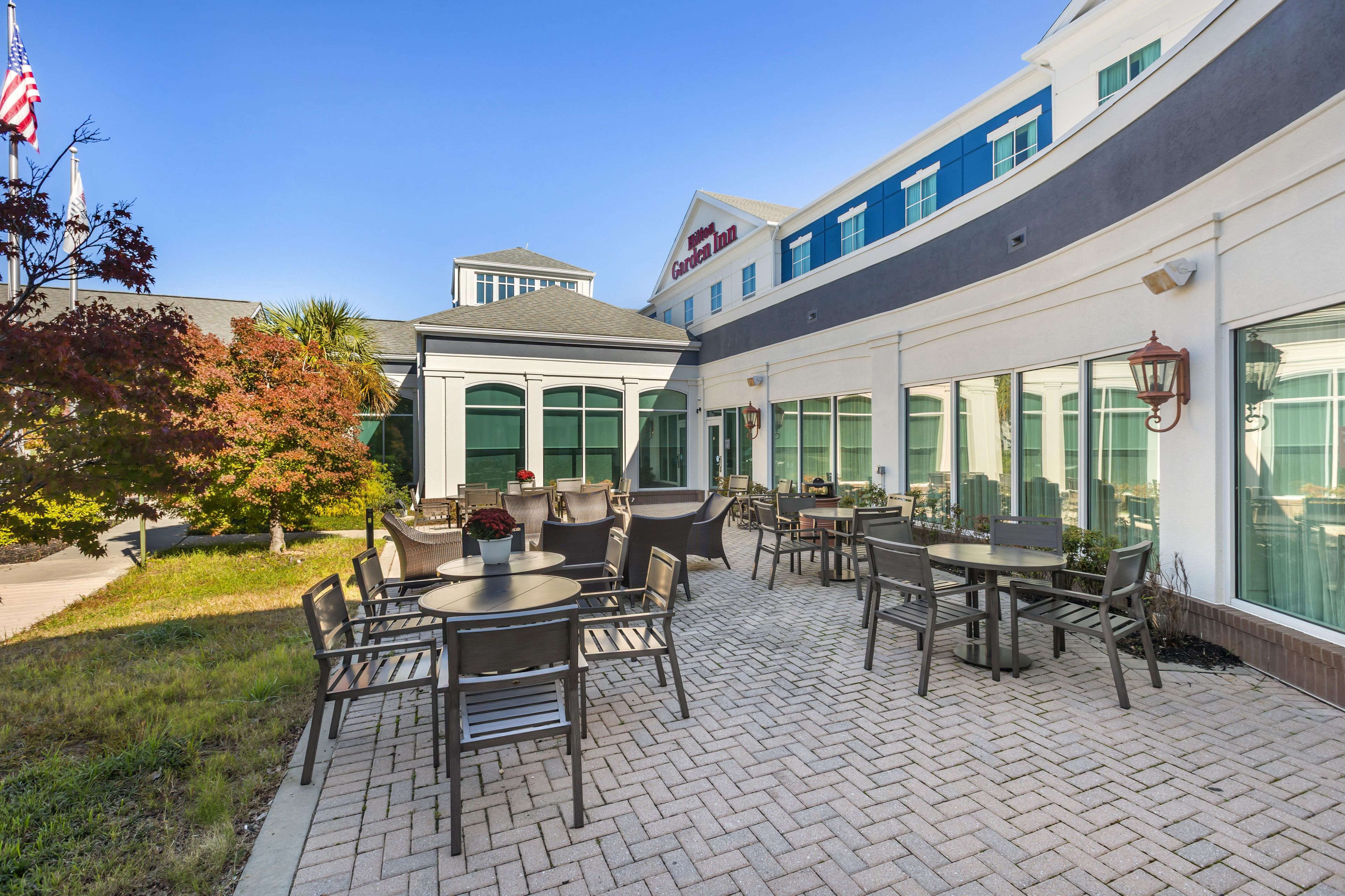Eine Hotelterrasse mit Sitzgelegenheiten im Freien und Blick auf das Gebäude.