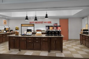 A modern kitchen with a central island, coffee machines, and a breakfast sign. - Hampton Inn & Suites Huntersville (Huntersville)