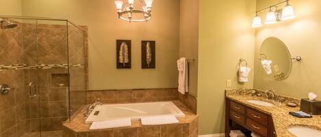 A modern bathroom with a glass-enclosed shower, a freestanding bathtub, and a vanity with dual sinks.