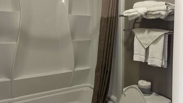 Une salle de bain avec une baignoire, des toilettes et un porte-serviettes.