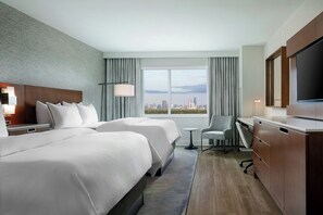 A hotel room with two beds, a desk, a chair, a TV, and a large window with a city view. - The Westin Houston, Memorial City (Houston)