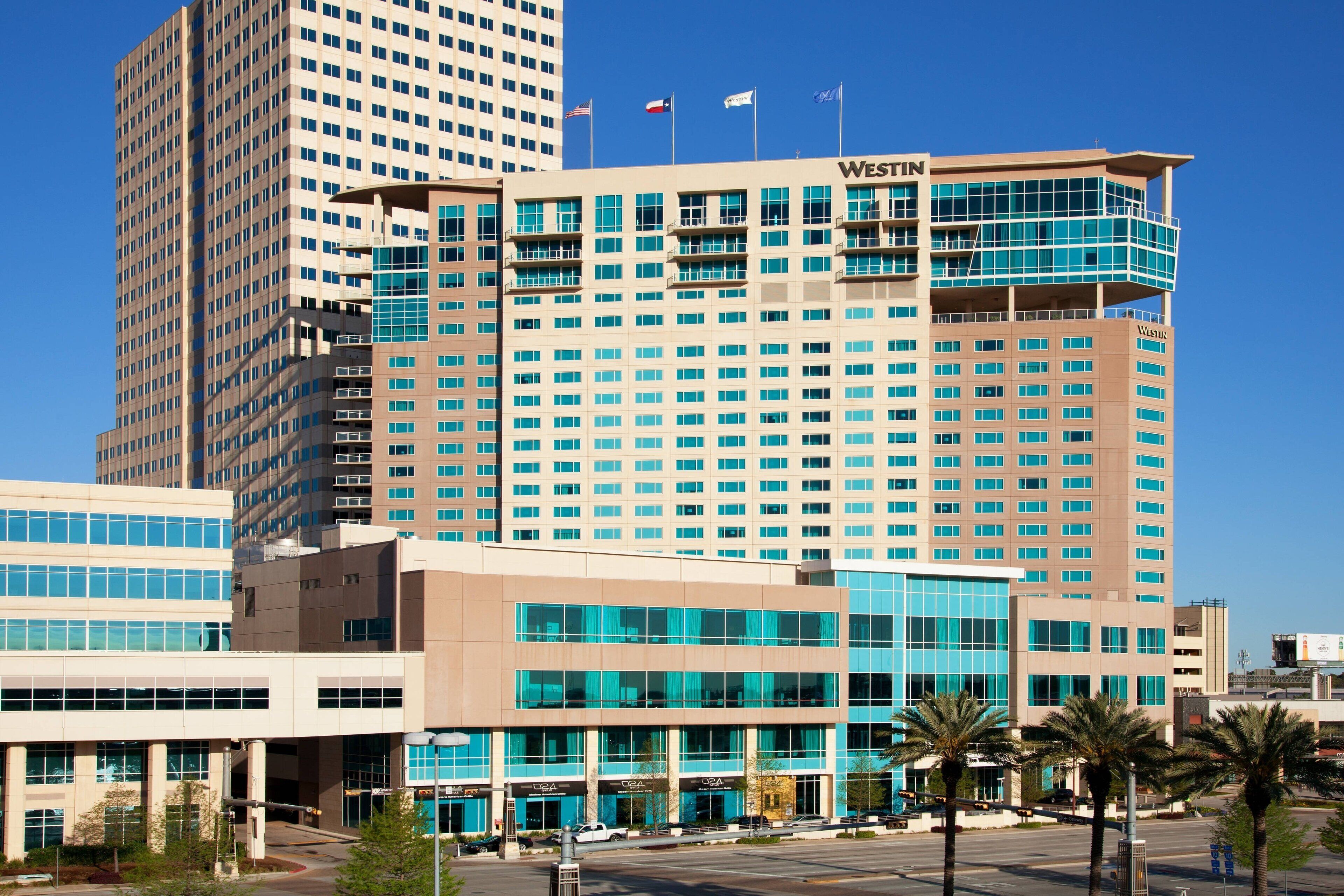 Un hotel moderno con un llamativo letrero de 'Westin', que presenta una estructura de varios pisos con numerosas ventanas y un techo plano.