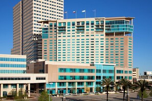 Un hotel moderno con un llamativo letrero de 'Westin', que presenta una estructura de varios pisos con numerosas ventanas y un techo plano.