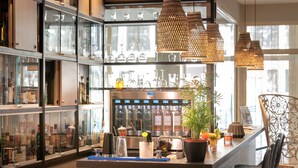 Un espace bar doté d'une vitrine, de lampes suspendues en osier et d'une plante en pot.