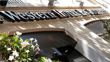 A sign for the Western Hotel & Suites with a modern architectural design.