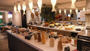 Un espace buffet proposant une variété de plats et d’accompagnements, éclairé par des luminaires suspendus au design moderne.