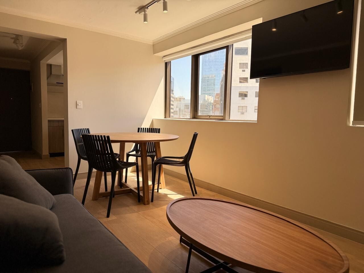 Una sala de estar moderna con comedor, un sofá, una mesa y sillas.