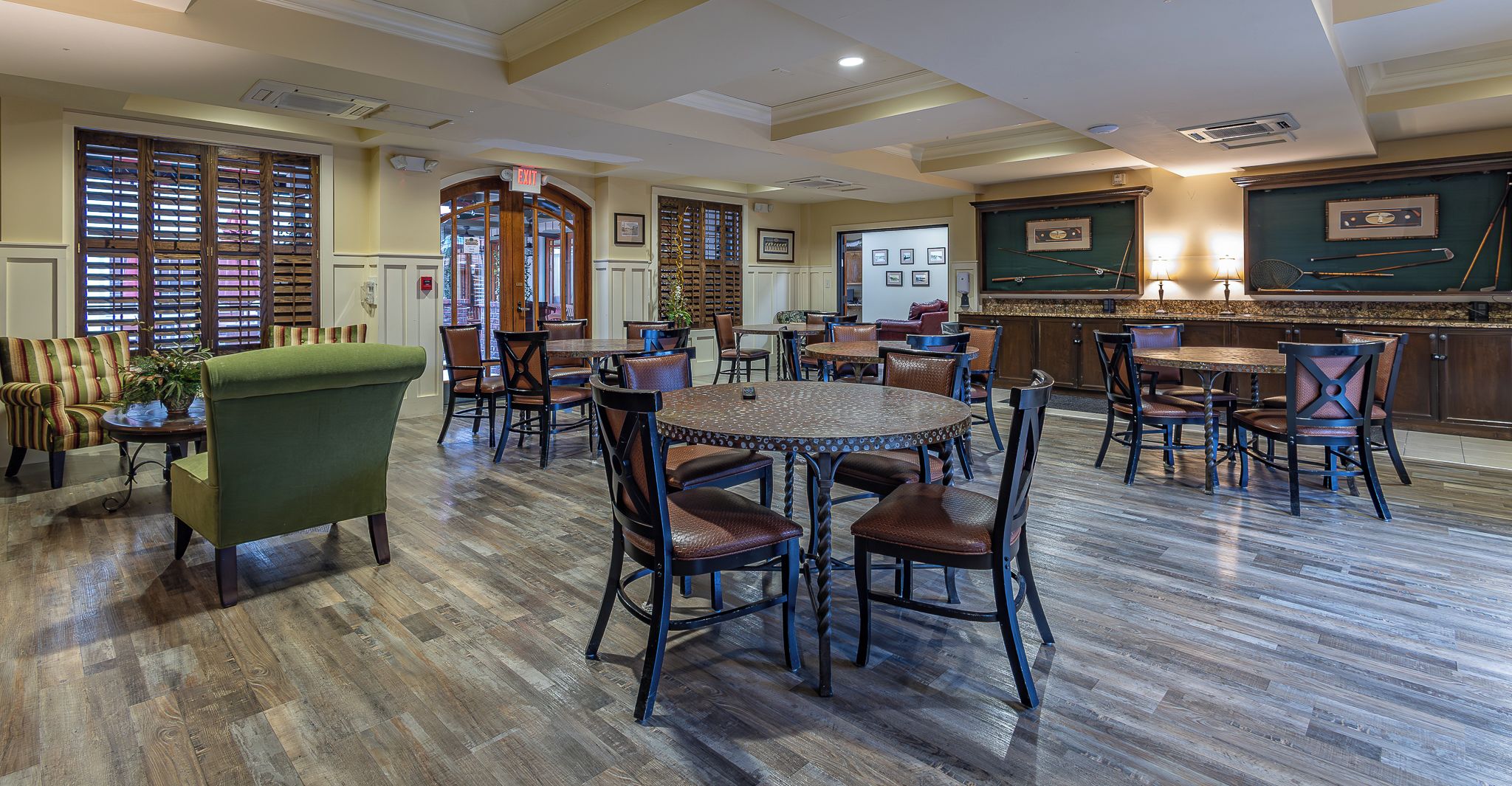 A dining area with wooden flooring, round tables, and chairs.