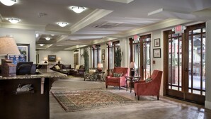 A hotel lobby with a reception desk, seating area, and large windows. - Willow Lodge (Murrells Inlet)