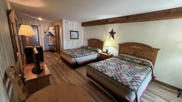 A hotel room with two beds, a round table, a lamp, and a star decoration on the wall.