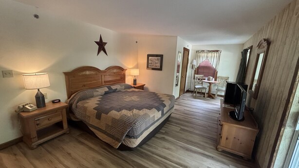 A bedroom with a wooden bed, bedside lamps, a desk with a computer, and a star decoration on the wall.