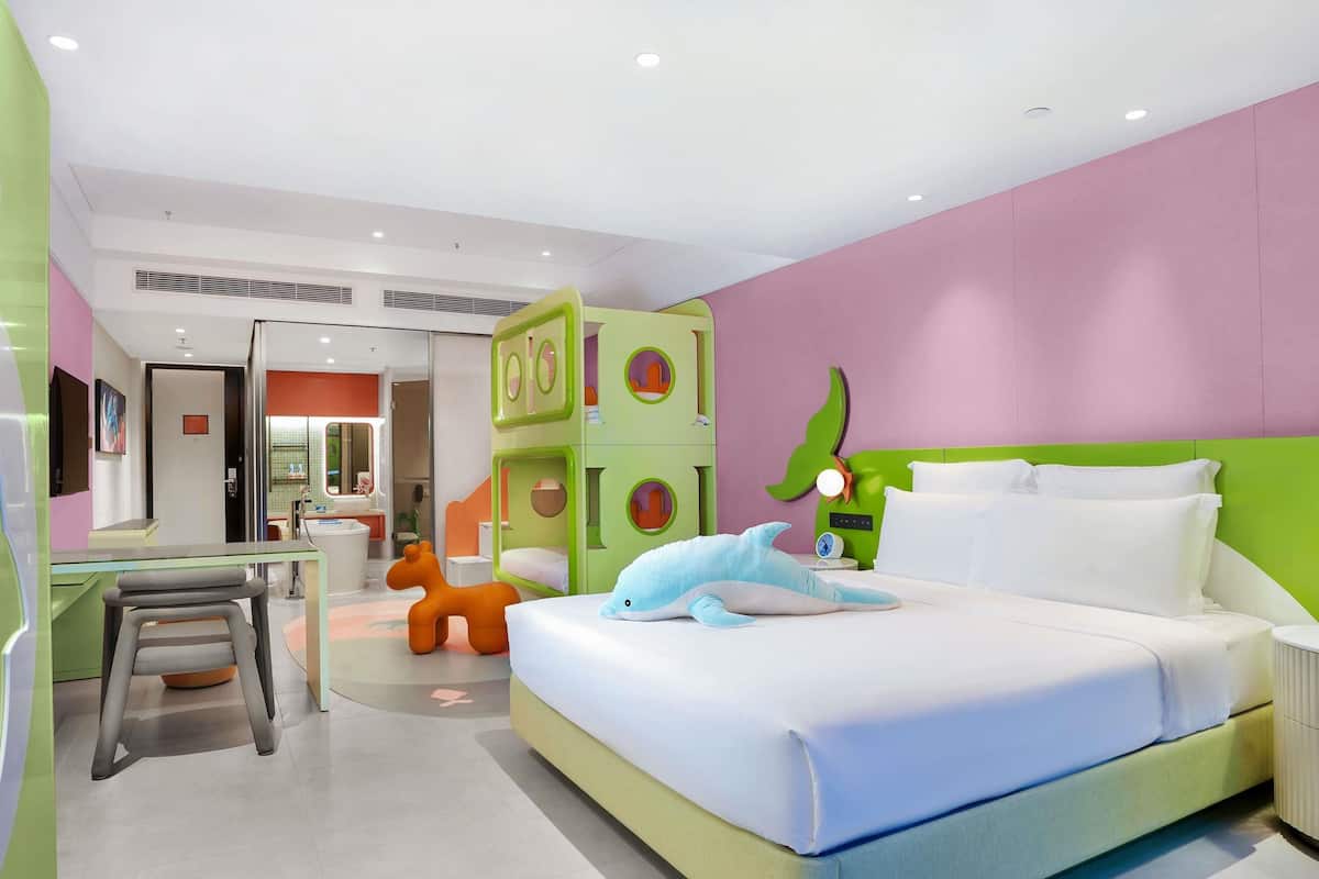 A modern bedroom with a bed, a desk, and a chair.