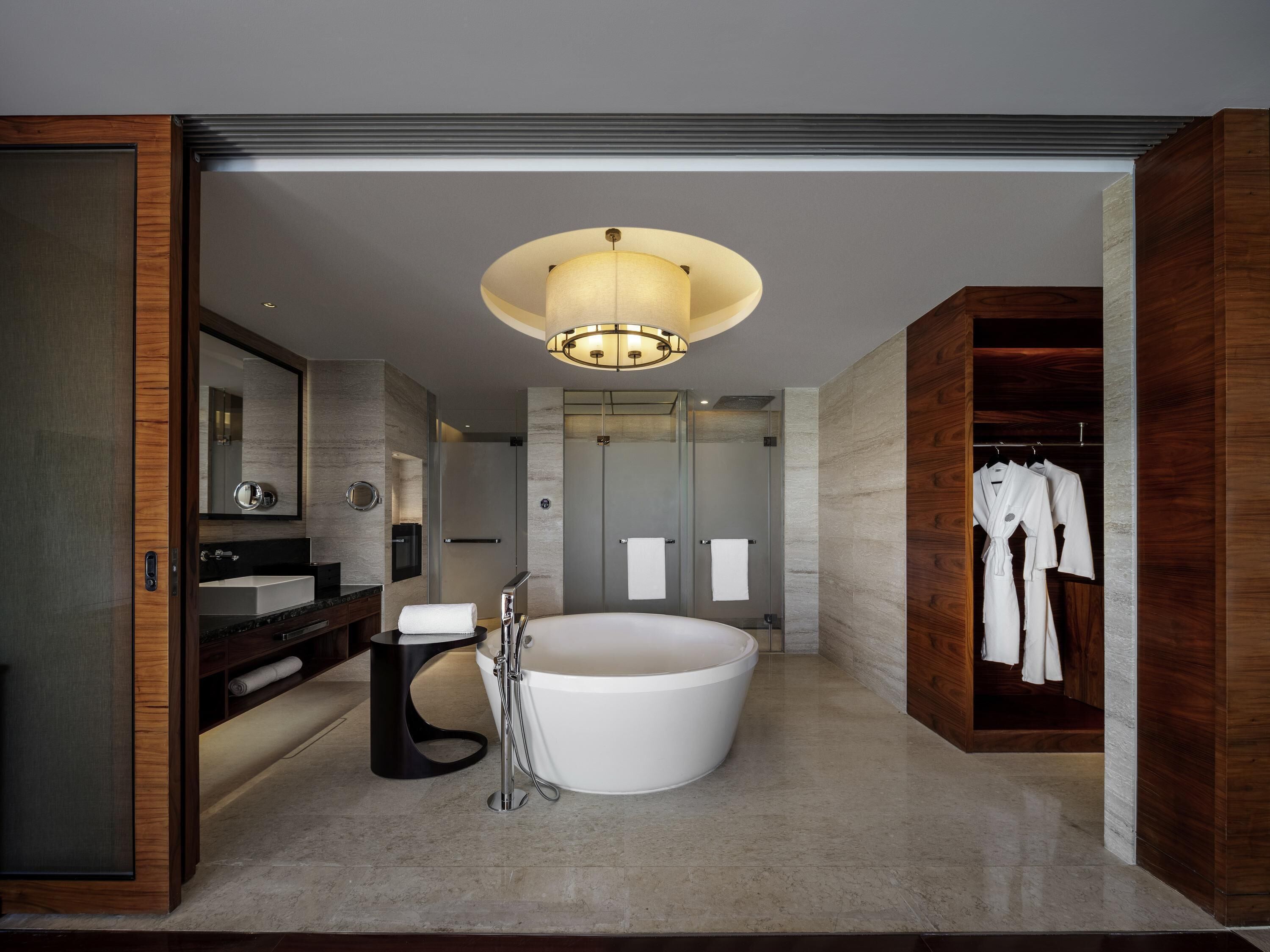 A modern bathroom with a freestanding bathtub, a vanity with a mirror, and a walk-in shower.